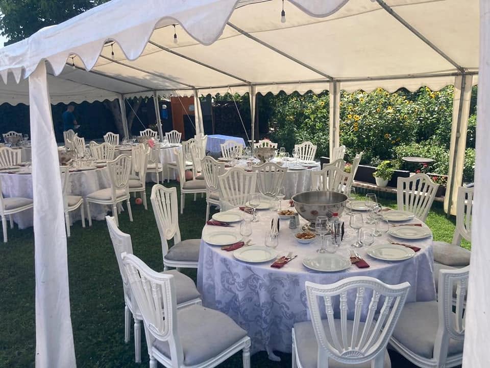 Cort alb cu mese și scaune elegante în grădină