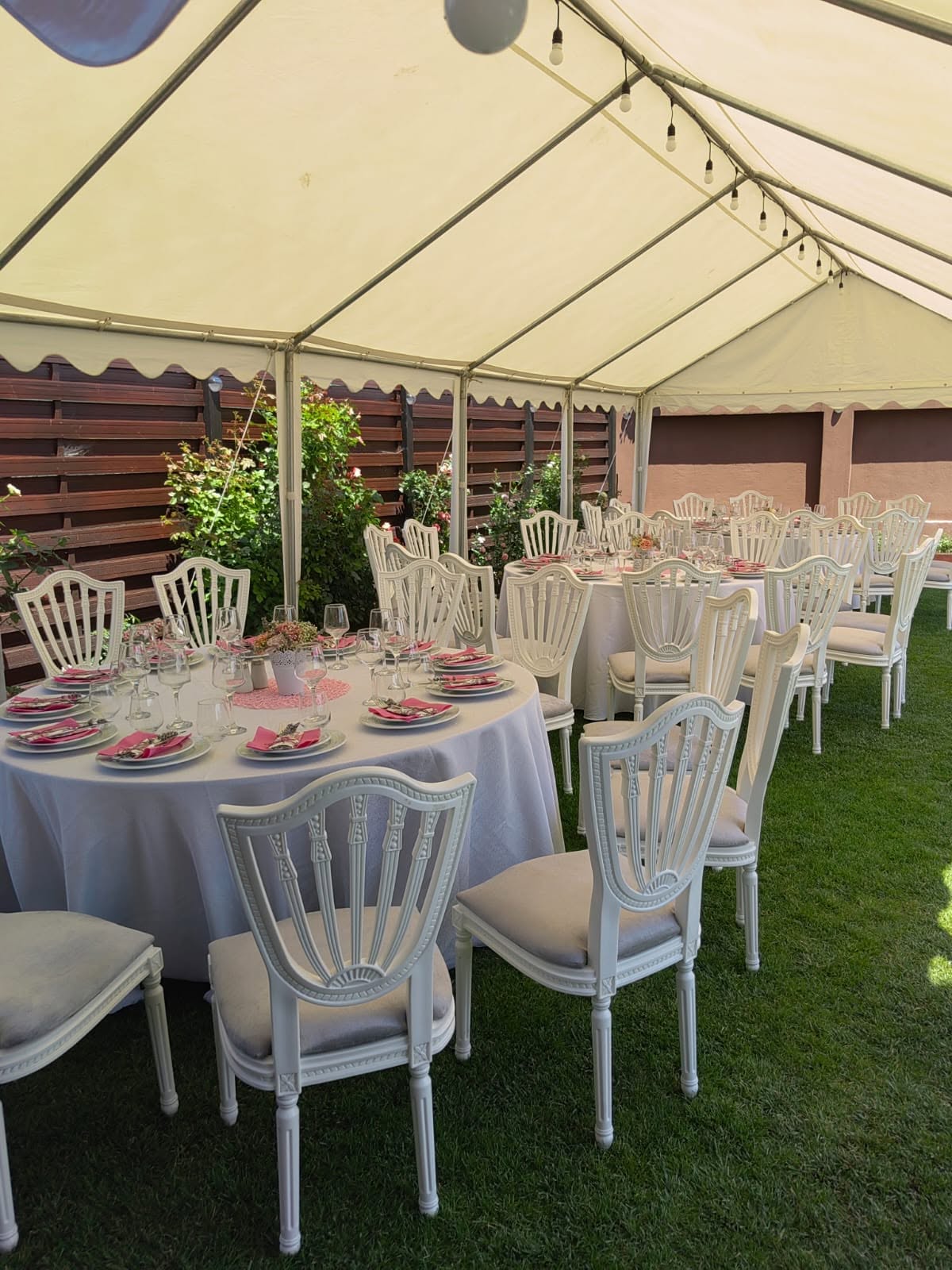 Cort alb elegant, complet echipat, amenajat în grădină pentru un eveniment